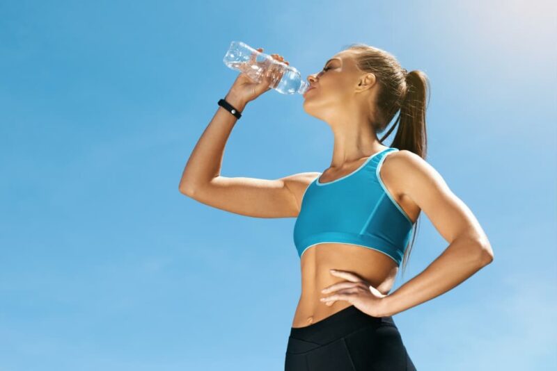 A woman hydrating herself with water before working out