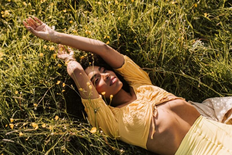 A woman lying on grass for spiritual cleansing and grounding