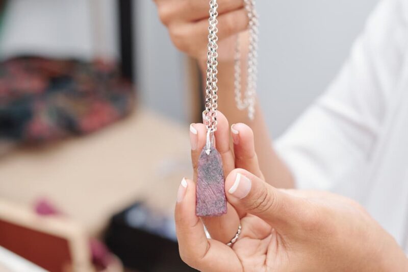 A woman holding a rose quartz necklace for good luck